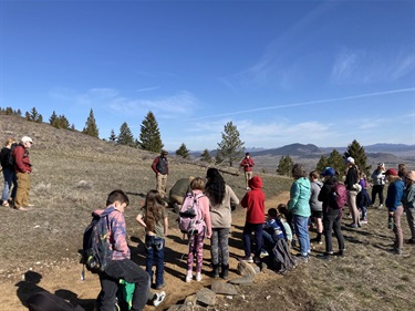 Students stand next to a trail on Mount Helena.