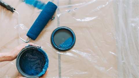 Can of blue paint with a paint roller.
